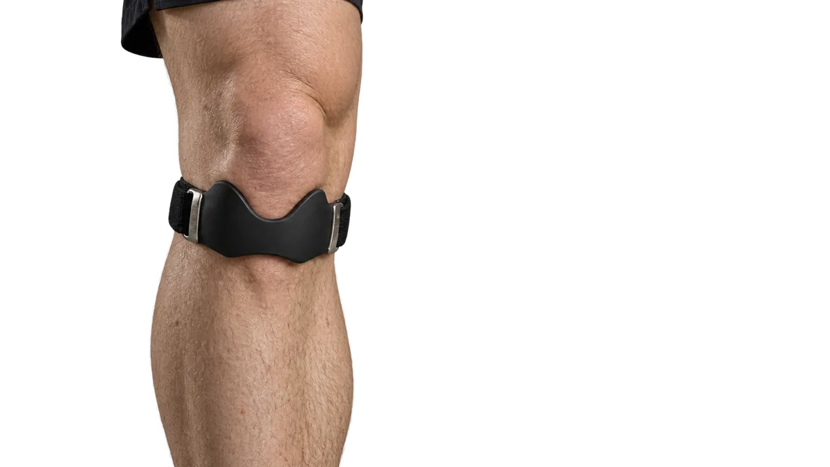 Genou d’un coureur avec la sangle rotulienne portée juste sous la rotule