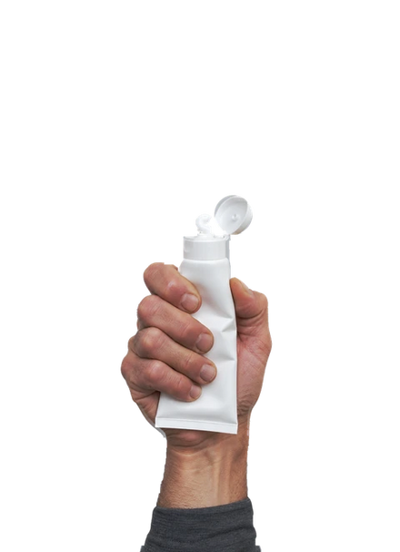 Main qui presse un tube de crème hydratante