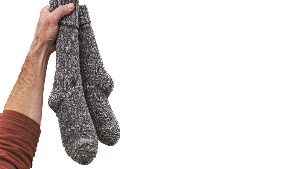 Main qui tient une paire de bas de laine