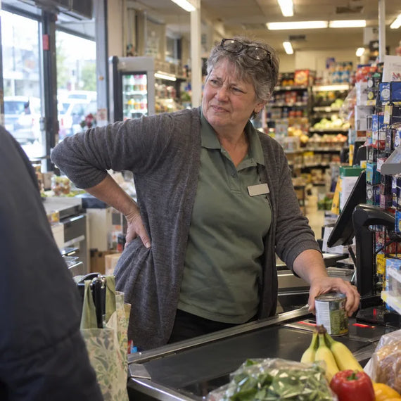Caissière d’épicerie qui se tient le bas du dos