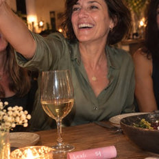 Femme qui rit à un souper entre amies, le stick sur la table