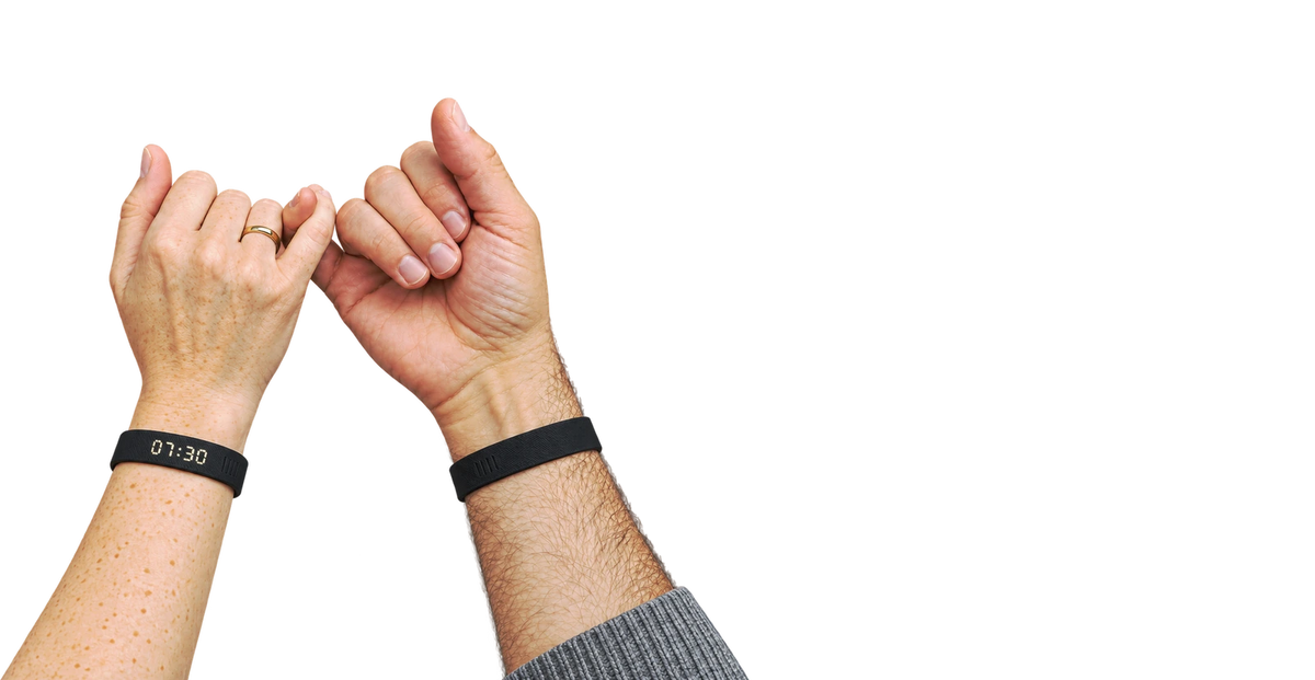 Deux mains qui se font une promesse du petit doigt, bracelets WAKE aux poignets